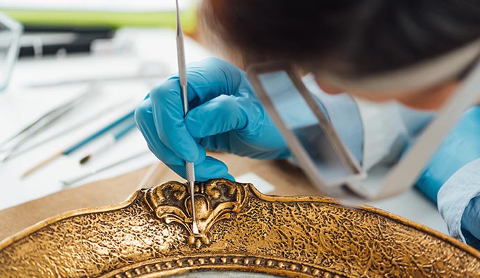 Professional worker cleaning an antique photo frame